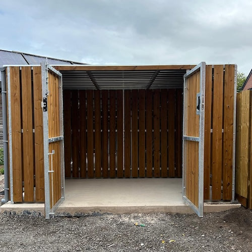 Timber clad cycle shelter with wood panels and curved roof housing five bikes