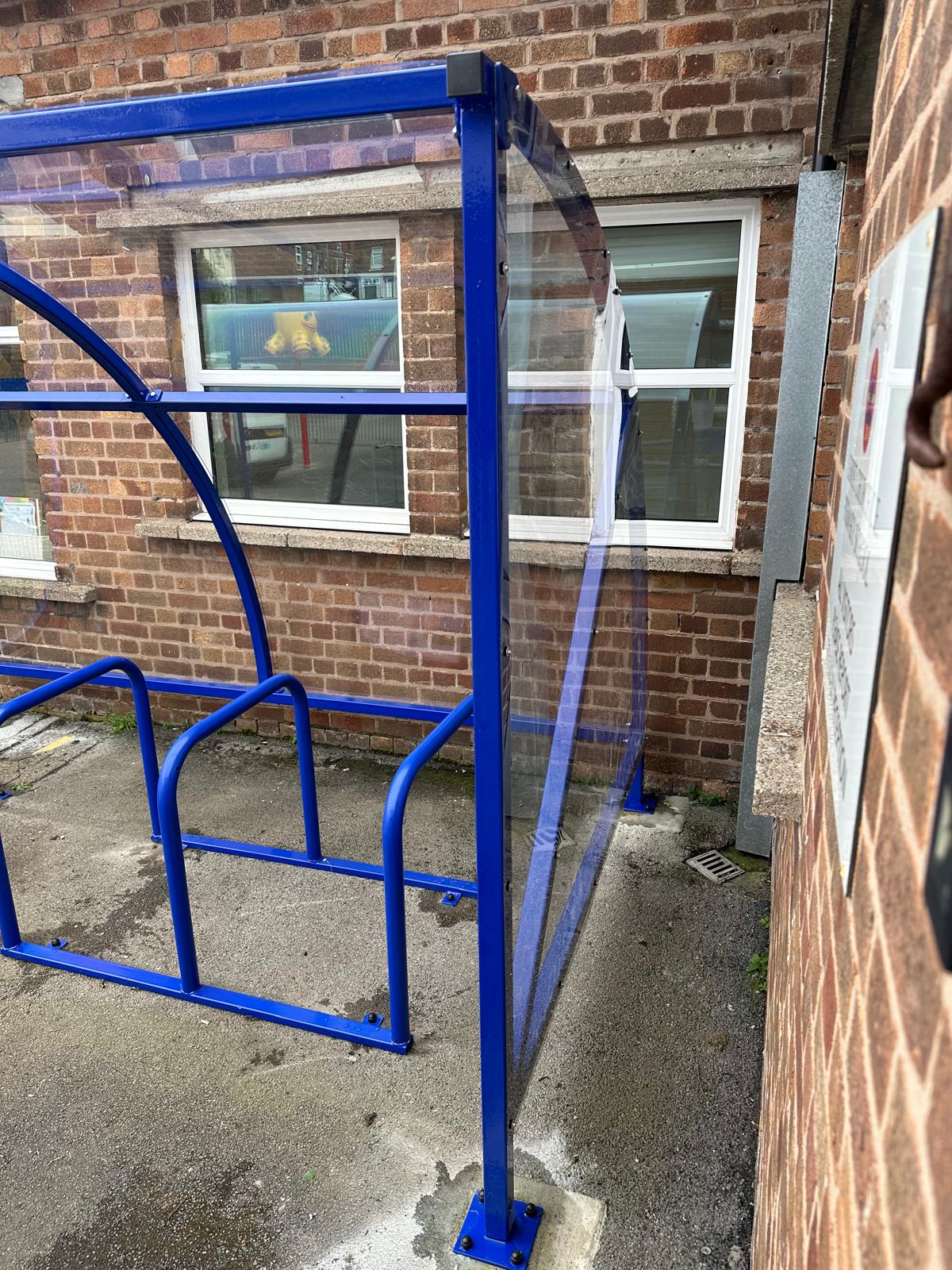 Curved cycle shelter called “The Rosie” featuring sleek curved roof and steel frame
