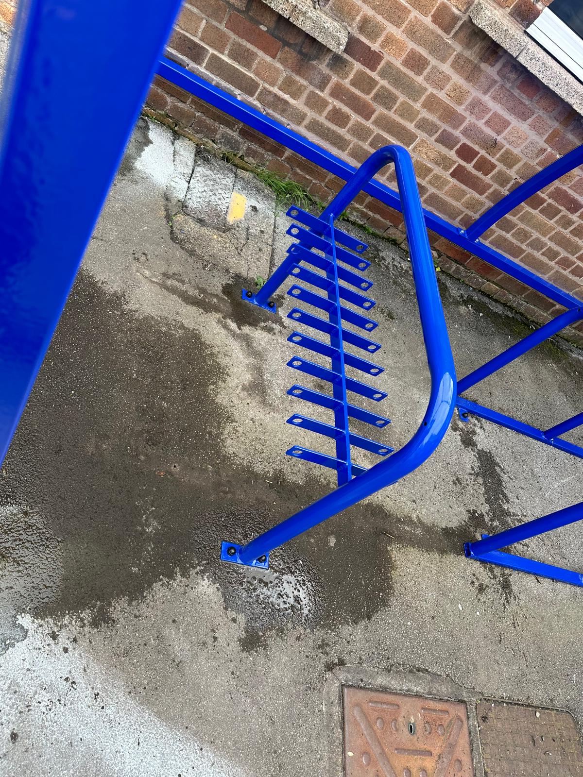 Curved cycle shelter called “The Rosie” featuring sleek curved roof and steel frame