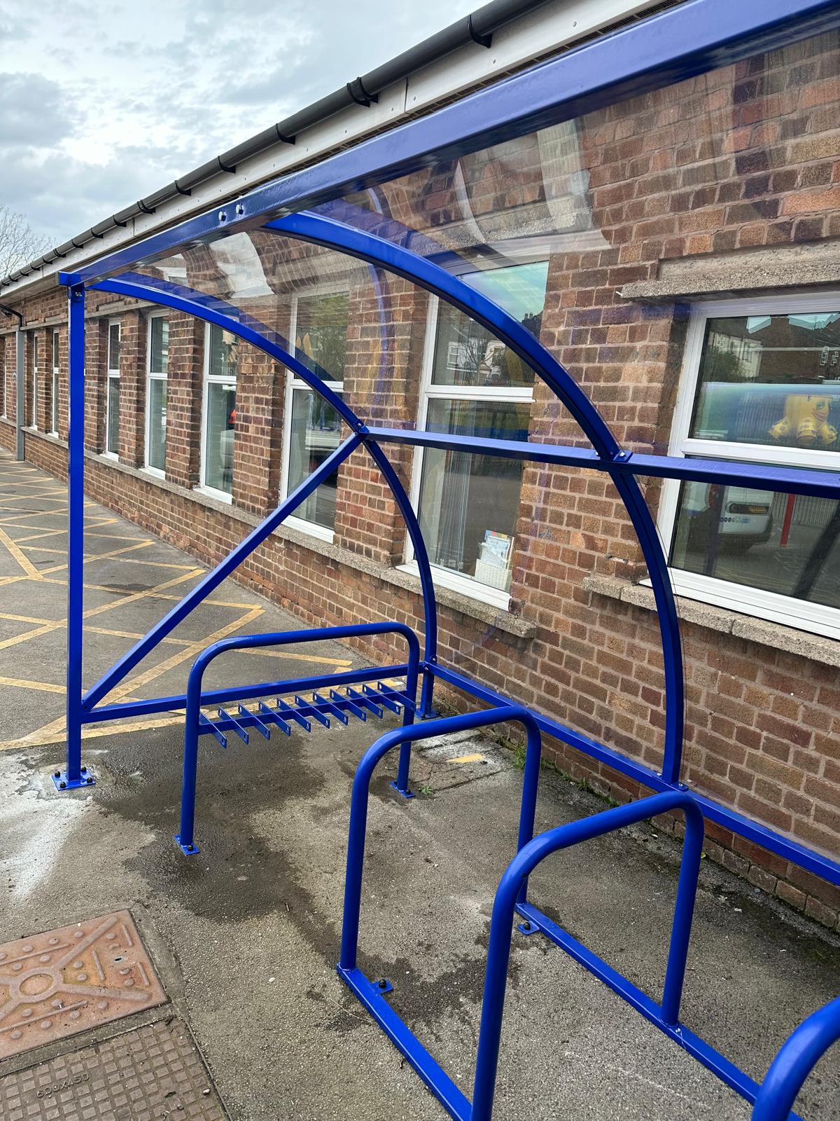 Curved cycle shelter called “The Rosie” featuring sleek curved roof and steel frame