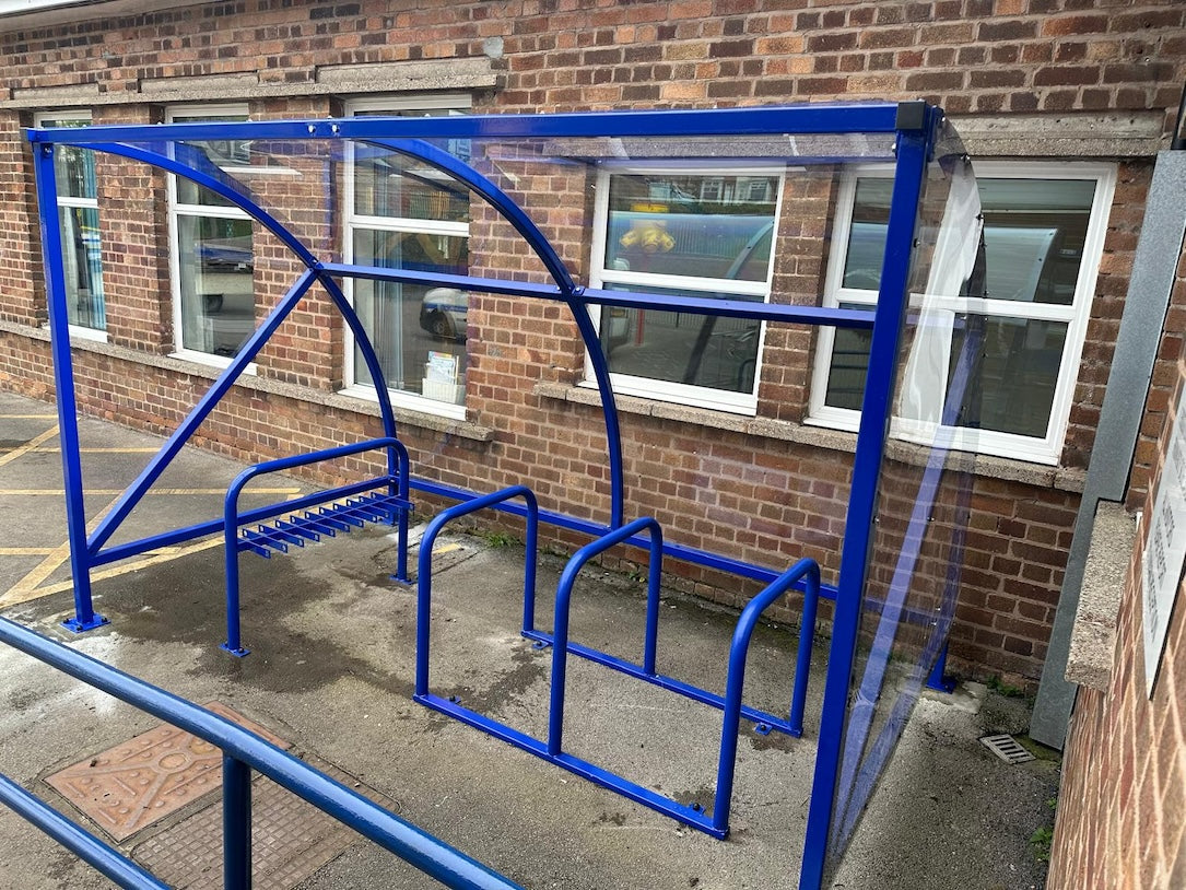 Curved cycle shelter called “The Rosie” featuring sleek curved roof and steel frame