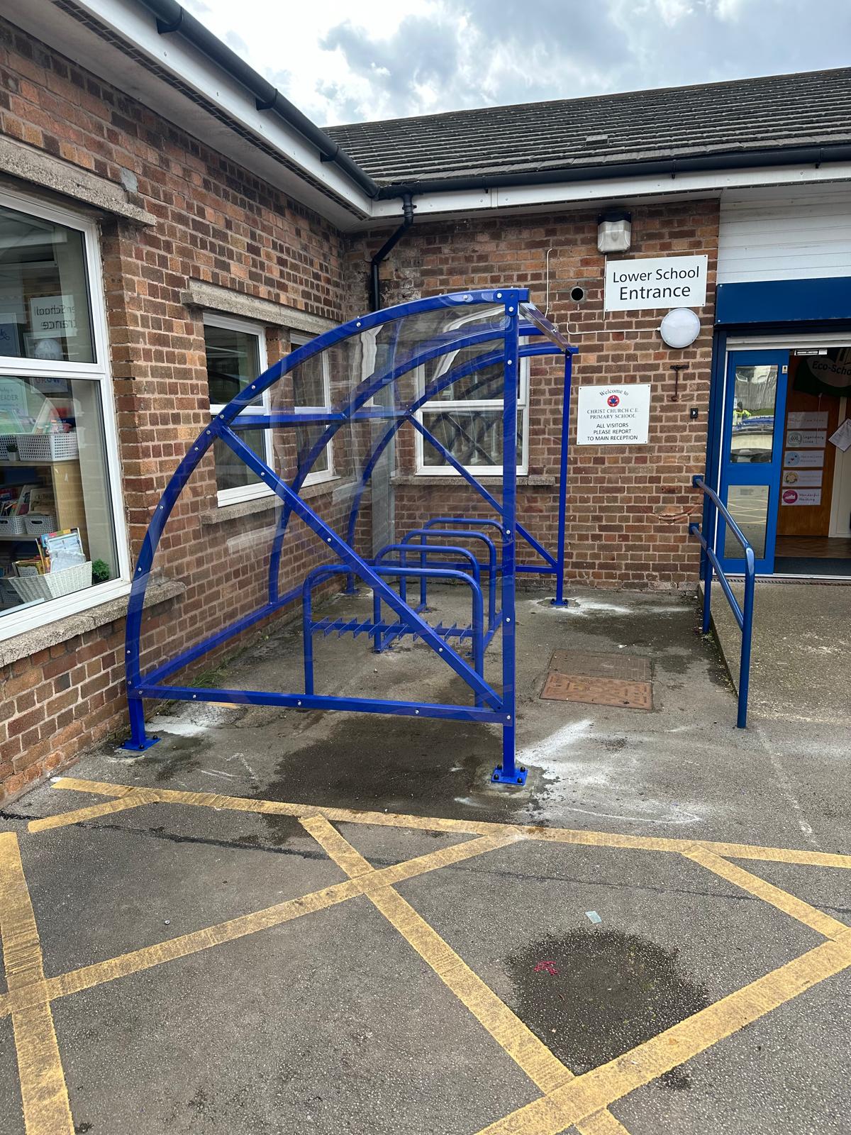 Curved cycle shelter called “The Rosie” featuring sleek curved roof and steel frame
