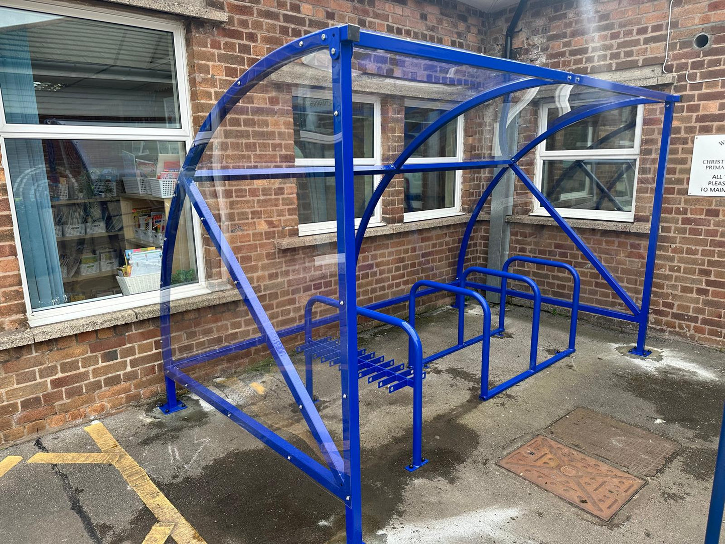 Curved cycle shelter called “The Rosie” featuring sleek curved roof and steel frame