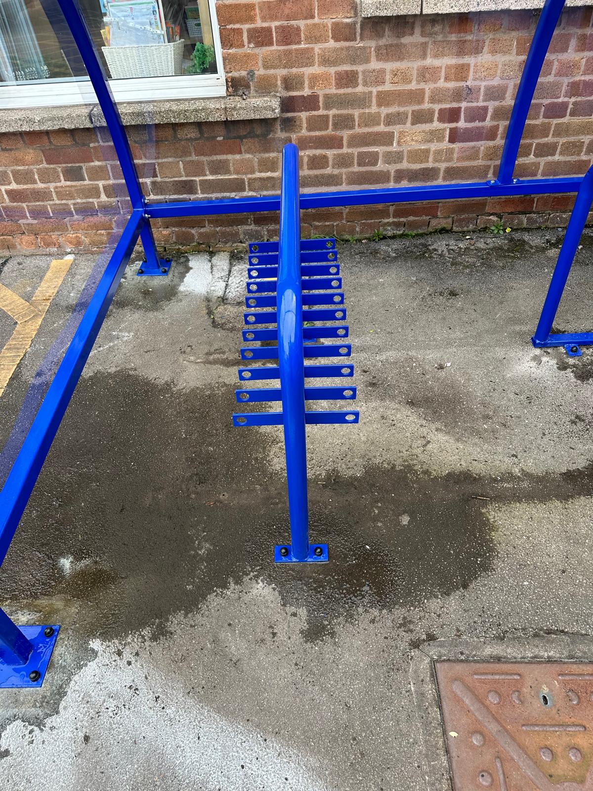 Curved cycle shelter called “The Rosie” featuring sleek curved roof and steel frame