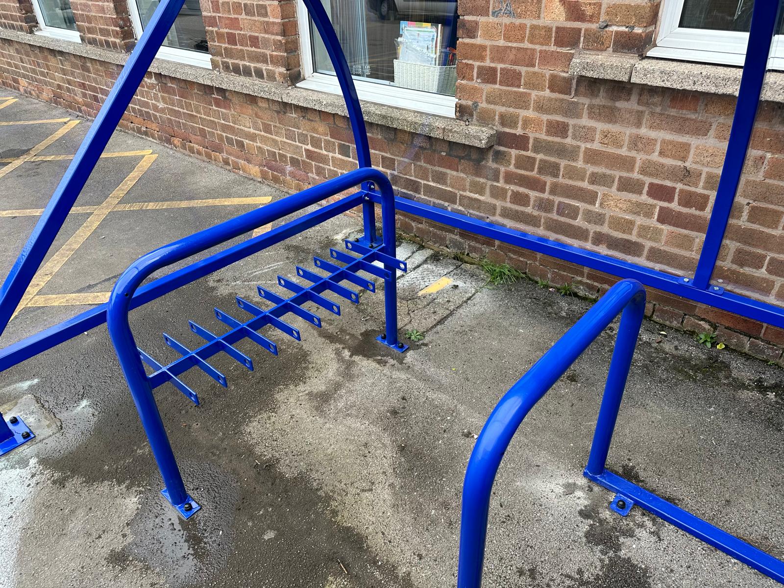 Curved cycle shelter called “The Rosie” featuring sleek curved roof and steel frame
