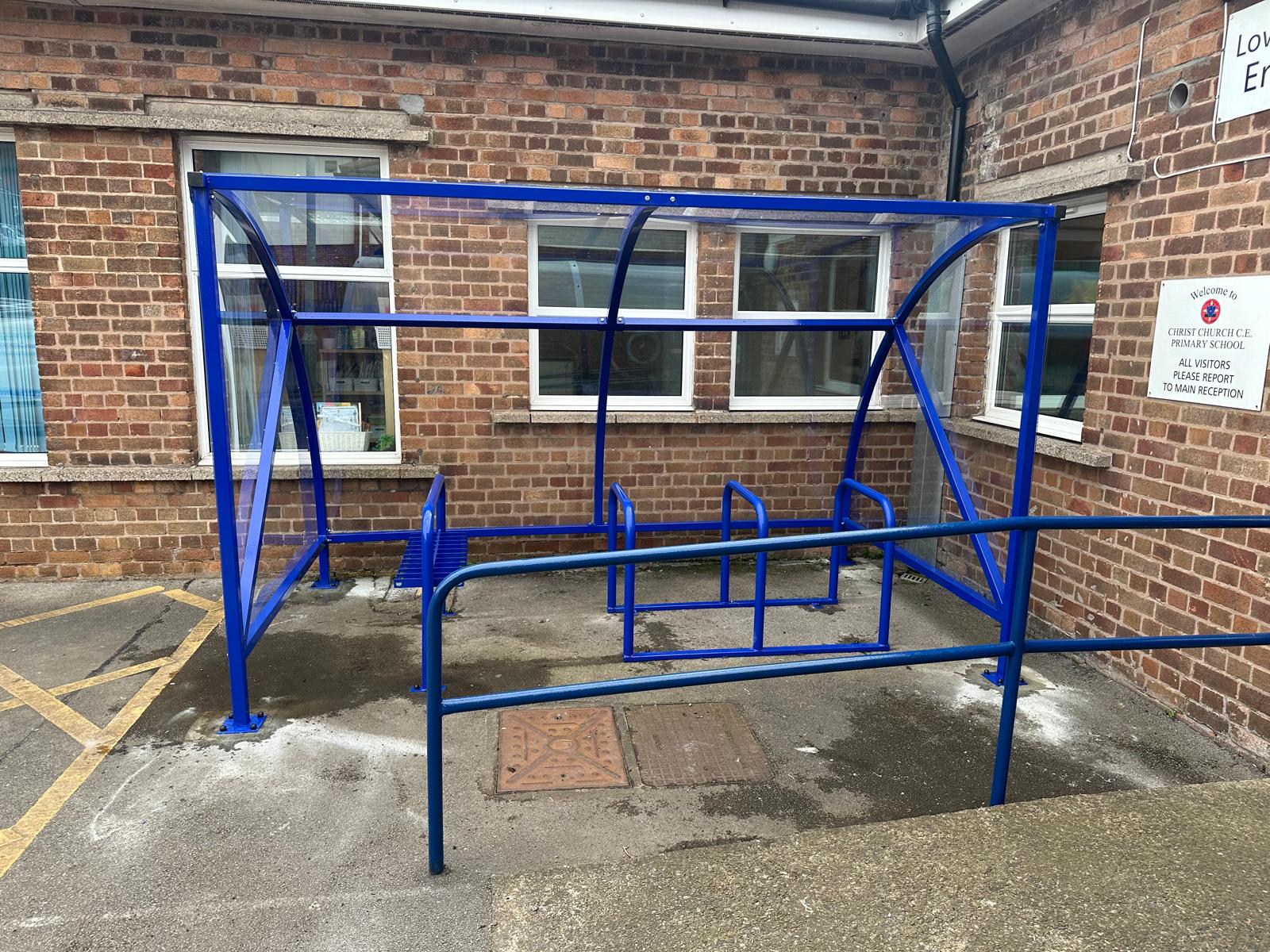 Curved cycle shelter called “The Rosie” featuring sleek curved roof and steel frame