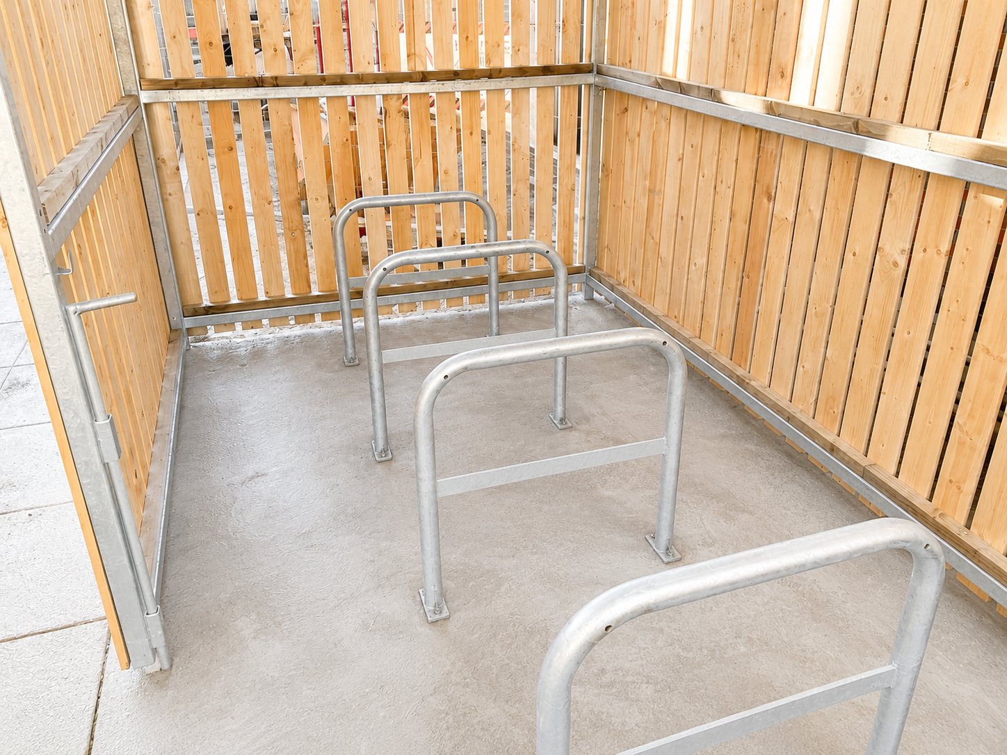 Galvanised Sheffield cycle stands installed inside a timber-clad cycle shelter

